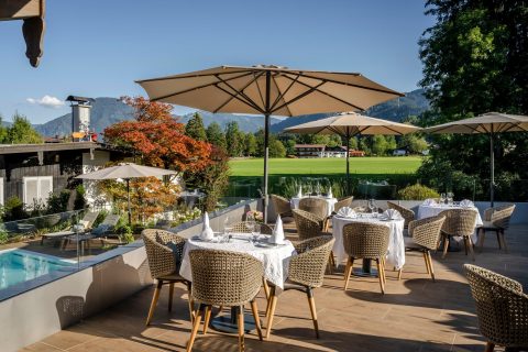 sonnenterrasse mit blick zum pool und in die bergwelt schoener sommertag